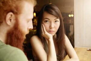 Brunette woman and ginger man sitting in cafe