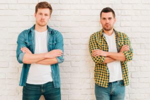 portrait-two-young-male-friends-with-their-arms-crossed-looking-camera