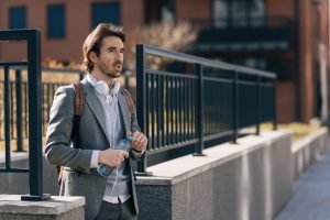 young-businessman-with-bottle-water-walking-city